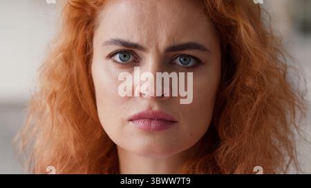 Primo piano viso femminile serio arrabbiato cattivo umore stressato offeso deluso frustrato ritratto capelli di zenzero donna caucasica ragazza signora a casa Foto Stock