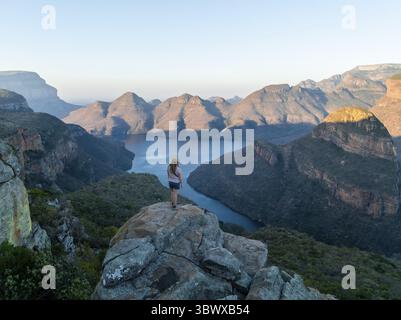 Escursionista godendo del panorama, Blyde River Canyon con la vetta dei tre Rondawels, vista del canyon con il fiume Blyde e le montagne Table, paesaggio del canyon, Foto Stock