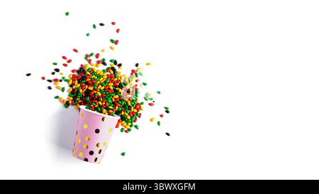 Tazza di carta con semi di girasole di cioccolato colorati isolati su sfondo bianco. Foto di alta qualità Foto Stock