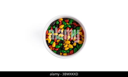 Tazza di carta con semi di girasole di cioccolato colorati isolati su sfondo bianco. Foto di alta qualità Foto Stock