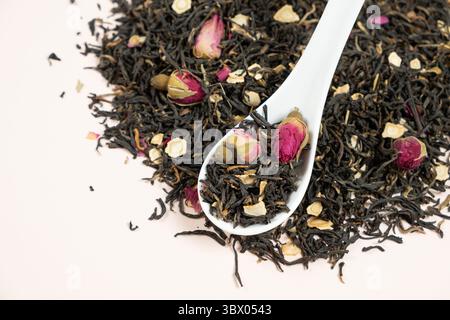 Composizione del tè nero con pezzi di ginseng e rose del tè. Foto Stock