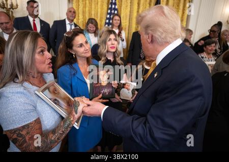 Il presidente Donald Trump parla con i membri del gruppo Angel Families durante una cerimonia della Casa Bianca che riconosce le famiglie che hanno perso i propri cari a causa di overdose di droga e la cerimonia coincide con la firma della legge HALT Fentanyl. 16 luglio 2025. Washington, DC, immagine gentilmente concessa dalla Casa Bianca. Foto Stock