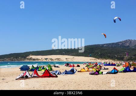 Colorata scena di kitesurf a Tarifa in Spagna con aquiloni in acqua e sulla spiaggia Foto Stock