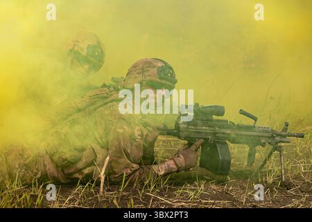 12 agosto 2021 - Baturaja, Indonesia - Un soldato dell'esercito americano con Task Force Warrior sorride attraverso una granata gialla fumogena mentre si delinea con una mitragliatrice leggera M249 durante un raggio di fuoco vivo nella Baturaja Training area, Indonesia, il 12 agosto 2021. Garuda Shield 21 è un'esercitazione congiunta di due settimane tra l'esercito degli Stati Uniti e Tentara Nasional Indonesia (TNI-ad Indonesia Armed Forces). Lo scopo di questo esercizio congiunto è quello di migliorare e arricchire le capacità di guerra nella giungla sia dell'esercito americano che dell'esercito indonesiano. (Foto US Army di SPC. Rachel Christensen) (immagine di credito: © U.S. Army/ZUMA Press Wire se Foto Stock