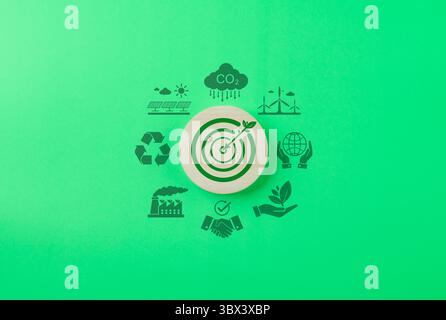 Energia verde e sostenibilità. Icona del bersaglio in legno con foglie e freccette, circondata da icone di energia verde e sostenibilità Foto Stock