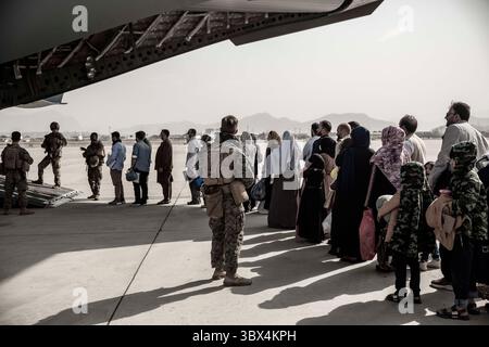 30 agosto 2021, Kabul, Afghanistan: Gli evacuati aspettano di salire a bordo di un Boeing C-17 Globemaster III durante un'evacuazione all'aeroporto internazionale Hamid Karzai, Kabul, Afghanistan. I membri del servizio degli Stati Uniti stanno assistendo il Dipartimento di Stato con un'operazione di evacuazione non combattente (NEO) in Afghanistan. (Immagine di credito: © Victor Mancillal/U.S. Marines/ZUMA Press Wire Service/ZUMAPRESS.com) Foto Stock