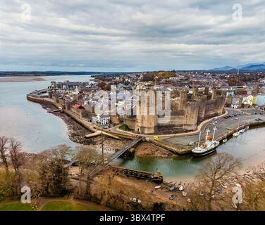 Una vista aerea attraverso la penisola verso la città e il castello di Caernarfon, Galles, in primavera Foto Stock