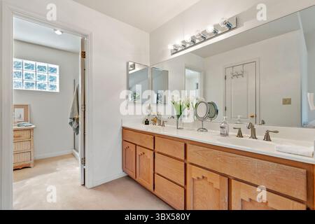 Un bagno spazioso con due lavandini e un grande ed elegante specchio Foto Stock
