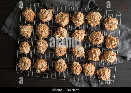 Macaron al forno su un rack di raffreddamento a filo: Biscotti appena sfornati al cocco e alle meringhe rinfrescati su una griglia metallica Foto Stock