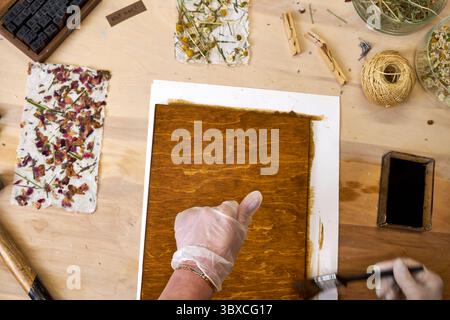 Pannello in legno spazzolato per artigianato decorativo con carta floreale fatta a mano. Progetto artistico ecologico con materiali naturali e carta botanica. DI creativo Foto Stock