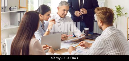 Uomini d'affari che lavorano a una riunione con documenti finanziari insieme. Foto Stock