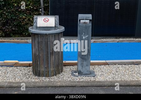 Bidone per rifiuti e sigarette a doppia funzione posizionato su ghiaia. Foto Stock