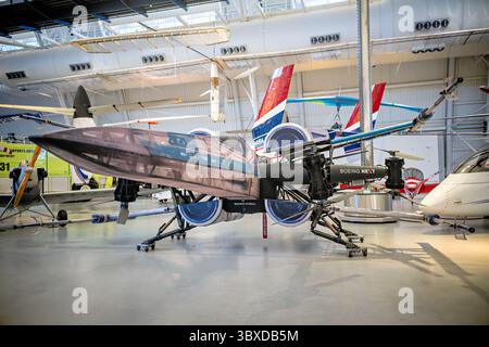 WASHINGTON DC - il drone Boeing Cargo Air Vehicle (CAV) mostra il suo costume da combattimento X-Wing dell'attrazione Star Wars: Galaxy's Edge del 2019 che si apre al Walt Disney World di Orlando, Florida. Boeing ha collaborato con la Walt Disney Company per montare telai X-Wing su questi grandi droni eVTOL (elettrici verticali decollo e atterraggio), che gli operatori hanno volato a distanza durante gli eventi di debutto dell'attrazione, mentre i faretti ultravioletti hanno illuminato solo le porzioni in costume. Il CAV è un aeromobile completamente elettrico senza equipaggio in grado di trasportare 225 kg (500 libbre) di carico, sviluppato da Boeing Beginning Foto Stock