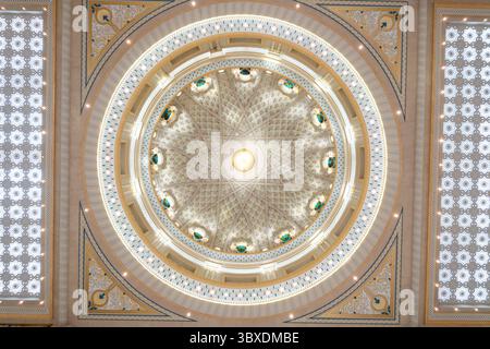 Cupola decorata con intricati motivi geometrici e una luce centrale. Il design simmetrico presenta dettagli dorati, blu e bianchi, incorniciati da motivi Foto Stock