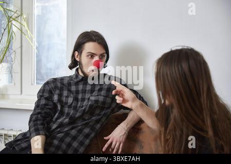 Due tizi vanno in giro come clown a casa Foto Stock