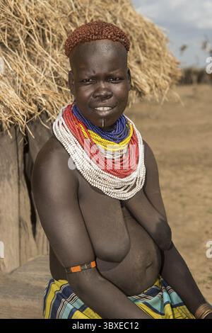 Donna del gruppo etnico Nyangatom, chiamata anche Bume, con collane colorate e il tipico stile di capelli color rame, Southern Omo Valley, Foto Stock