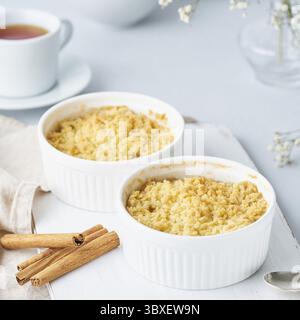Chiudere la mela sbriciolata con streusel. Vista laterale, primo piano. Colazione mattutina su un tavolo grigio chiaro Foto Stock