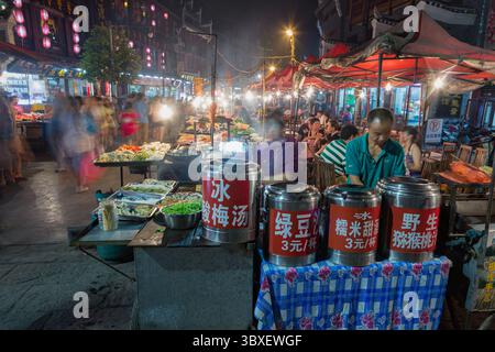 24 maggio 2013, Fenghuang, provincia di Hunan, Cina: Venditori di cibo con cibo in vendita nel mercato di strada di notte nell'antica città di Fenghuang, Cina. (Immagine di credito: © Jon G. Fuller/VW Pics via ZUMA Press Wire) Foto Stock