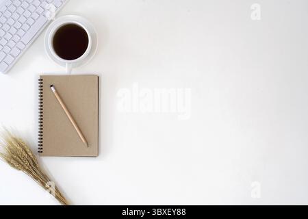 Vista superiore con spazio di copia per il testo. tastiera, tazza di caffè e notebook su sfondo bianco Foto Stock