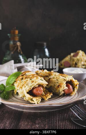 Cibo, salsicce avvolte in pancake di cavolo tagliati su un piatto con vista verticale Foto Stock