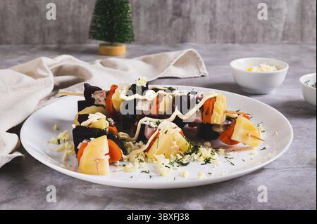 Cibo, insolito aringhe sotto un cappotto di pelliccia sugli spiedini sul tavolo Foto Stock