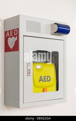 Defibrillatore semiautomatico esterno (AED) portatile montato a parete nei bagni pubblici dell'aeroporto Foto Stock