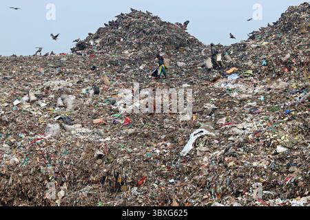 25 ottobre 2021, Dacca, Bangladesh: I raccoglitori di rifiuti delle persone raccolgono i rifiuti non biodegradabili da utilizzare per l'industria del riciclaggio nel sito di discarica di Dacca molte persone vivono raccogliendo rifiuti dalle montagne di rifiuti che vengono generati quotidianamente, per lo più dalla capitale Dacca. Il Bangladesh, l'ottavo paese più popoloso del mondo, ha attualmente un grave problema di inquinamento, a causa della produzione di rifiuti solidi nelle aree urbane del Bangladesh che ammonta a circa 25.000 tonnellate al giorno, il che si traduce in un aumento della produzione di rifiuti solidi. La città di Dacca produce un quarto di tutti i rifiuti urbani del paese. Il totale dei rifiuti solidi urbani è pr Foto Stock