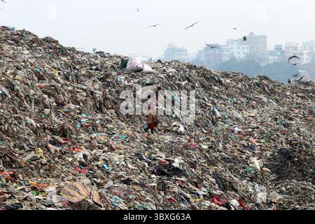 25 ottobre 2021, Dacca, Bangladesh: I raccoglitori di rifiuti delle persone raccolgono i rifiuti non biodegradabili da utilizzare per l'industria del riciclaggio nel sito di discarica di Dacca molte persone vivono raccogliendo rifiuti dalle montagne di rifiuti che vengono generati quotidianamente, per lo più dalla capitale Dacca. Il Bangladesh, l'ottavo paese più popoloso del mondo, ha attualmente un grave problema di inquinamento, a causa della produzione di rifiuti solidi nelle aree urbane del Bangladesh che ammonta a circa 25.000 tonnellate al giorno, il che si traduce in un aumento della produzione di rifiuti solidi. La città di Dacca produce un quarto di tutti i rifiuti urbani del paese. Il totale dei rifiuti solidi urbani è pr Foto Stock