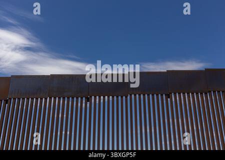 Muro di confine metallico vicino a Ciudad Juarez sotto un cielo blu, un punto focale nei dibattiti sulla migrazione e la sicurezza. Foto Stock