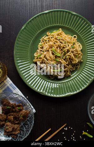 Vista dall'alto dei tagliatelle di sesamo su un piatto verde, vista dall'alto dei tagliatelle di ramen fritti con sesamo Foto Stock
