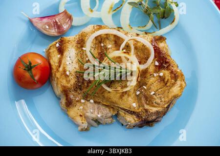 Succosa braciole di maiale alla griglia con anelli di cipolla, colorato ed elegante Foto Stock