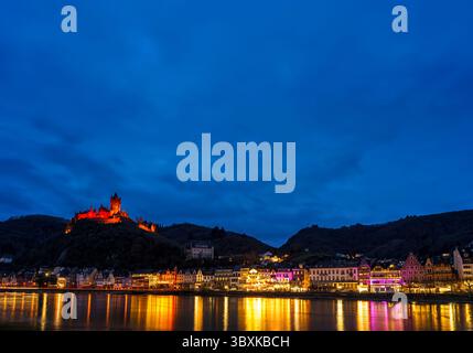 La pittoresca cittadina di Cochem, in Germania, brilla di notte nel cuore della valle della Mosella. Cochem offre una magica miscela di fascino medievale e vigneti Foto Stock