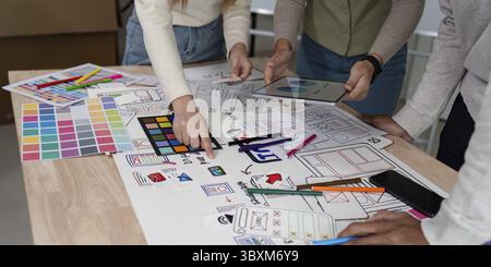 Brainstorming team di creativi graphic designer per il Web. I designer creativi presentano l'interfaccia utente ux al team. Riunione di lavoro del team di progettisti in ufficio Foto Stock