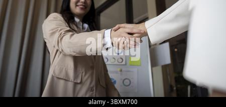 Primo piano di una stretta di mano professionale tra due professionisti in un ambiente di ufficio moderno, simbolo di partnership e accordo Foto Stock