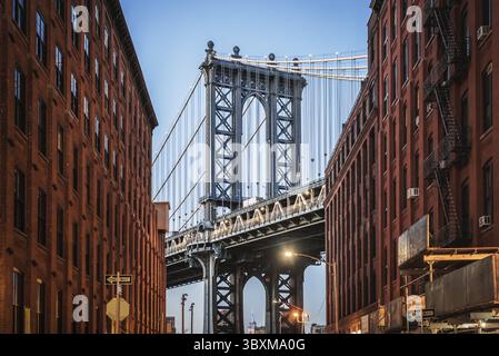 Dumbo - il famoso ponte di Manhattan tra due palazzi in mattoni rossi di Brooklyn in serata Foto Stock