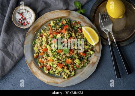 Insalata di tabbouleh con quinoa. Cibo orientale con verdure mix su tavola scura, dieta vegana. Vista dall'alto Foto Stock
