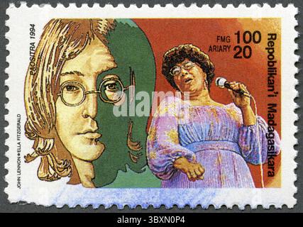 REPUBBLICA MALGASCIA - CIRCA 1994: Un francobollo stampato nella Repubblica malgascia Madagascar mostra John Lennon (1940-1980), Ella Fitzgerald (1917-1996), circa 1994 Foto Stock