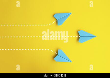 Aerei di carta blu che volano in direzioni separate Foto Stock