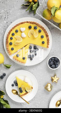 Cibo, tradizionale torta di limone francese con mirtilli su sfondo di pietra bianca. Vista dall'alto Foto Stock