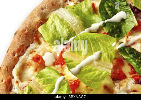 Primo piano dell'appetitosa pizza caesar con lattuga romaina fresca, condimento cremoso e condimenti saporiti Foto Stock