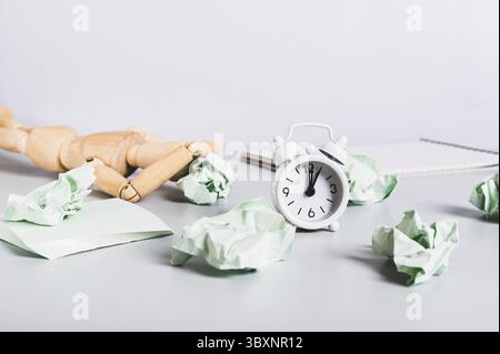 Cibo, uomo bruciato al lavoro, carta sguazzata, notebook e sveglia sulla scrivania Foto Stock