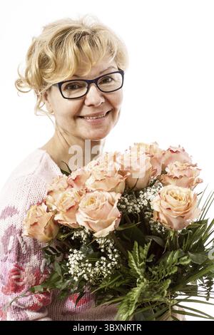 Bello, biondo donna matura con mazzo di rose Foto Stock