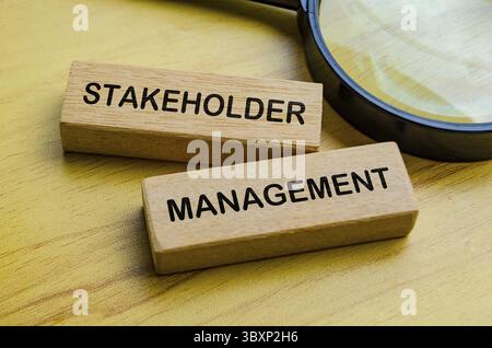 Testo di stakeholder Management su blocchi di legno con sfondo in lente di ingrandimento. Concentrarsi sul concetto di gestione delle parti interessate Foto Stock