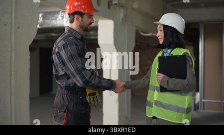 Business multietnico diversi costruttori stretta di mano accordo di partenariato costruzione costruzione cooperazione progetti di costruzione donna asiatica ispettore scuotimento Foto Stock