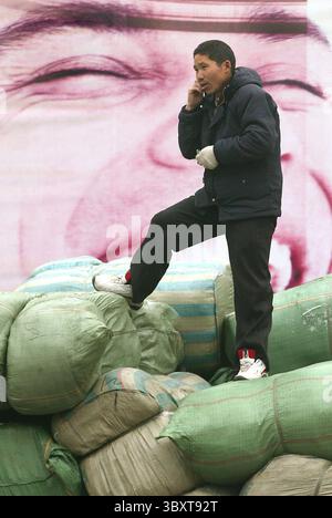 28 febbraio 2006, PECHINO, CINA: Un lavoratore cinese ascolta le istruzioni di carico mentre si trova sulla sommità di un camion imballato a Pechino, Cina, il 1° marzo 2006. Quest'anno la Cina affronterà sfide occupazionali "serie” e probabilmente creerà meno della metà dei posti di lavoro necessari per far fronte a eserciti in rapida crescita di nuovi in cerca di lavoro e licenziamenti di lavoratori, ha affermato in una pessima previsione il principale pianificatore economico del paese comunista. (Immagine di credito: © Stephen Shaver/ZUMA Press Wire) Foto Stock