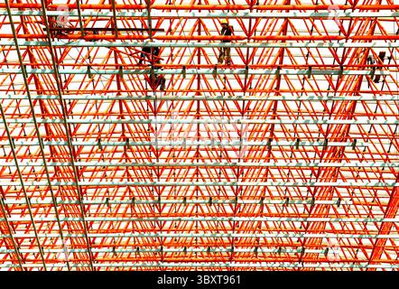 28 marzo 2006, PECHINO, CINA: I lavoratori assemblano impalcature su un importante cantiere commerciale destinato ad aprire poco prima delle Olimpiadi di Pechino del 2008, oltre ad essere una delle tante aree progettate per i visitatori delle Olimpiadi, il 28 marzo 2006. La Cina intende raggiungere una modernizzazione di base a metà del XXI secolo attraverso uno sviluppo pacifico. I prossimi 20 anni saranno molto importanti per il paese, poiché i suoi progressi nelle riforme, nell'apertura e nella costruzione di un'economia di mercato hanno raggiunto la fase critica. La Cina è ancora il più grande paese in via di sviluppo del mondo. Si trova di fronte a "difficoltà" Foto Stock