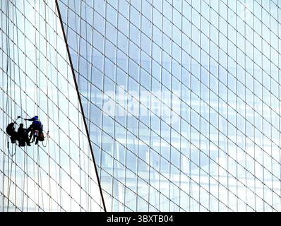 29 aprile 2007, PECHINO, CINA: Due lavavetri puliscono l'enorme esterno in vetro di un edificio per uffici nel centro di Pechino, Cina, il 29 aprile 2007. I funzionari stanno esaminando nuovi passi per rinfrescare l'economia sfrigolante della Cina, mentre la sua principale agenzia di pianificazione ha chiesto un credito bancario più stretto e restrizioni sulla costruzione, hanno riferito i media statali. Il rapporto ha suggerito che Pechino ritiene che le misure precedenti, tra cui un aumento del tasso di interesse ad aprile, non stiano contenendo la crescita incontrollata della spesa per le fabbriche e altre risorse che i leader cinesi temono potrebbero innescare una crisi finanziaria. (Immagine di credito: © Stephen Shave Foto Stock