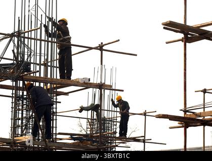 8 aprile 2010, PECHINO, CINA: Gli operai edili cinesi assemblano colonne di cemento armato prima che il cemento venga versato su un nuovo sito residenziale nel centro di Pechino, Cina, il 4 gennaio 2007. I funzionari stanno esaminando nuovi passi per rinfrescare l'economia sfrigolante della Cina, mentre la sua principale agenzia di pianificazione ha chiesto un credito bancario più stretto e restrizioni sulla costruzione, hanno riferito i media statali. Il rapporto ha suggerito che Pechino ritiene che le misure precedenti, tra cui un aumento del tasso di interesse ad aprile, non stiano contenendo la crescita fugace della spesa per le fabbriche e altre risorse che i leader cinesi temono potrebbero innescare Foto Stock