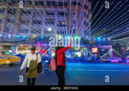 23 dicembre 2021, Kolkata, Bengala Occidentale, India: Si vede una ragazza scattare foto in una strada decorata con luci di natale prima della festa di natale a Kolkata. (Immagine di credito: © Debarchan Chatterjee/ZUMA Press Wire) Foto Stock