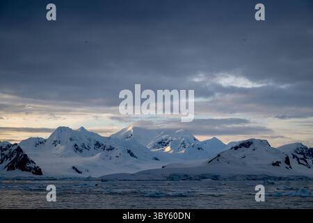 Il sole della mattina presto cade su una catena montuosa a Thorne Point, nella Terra di Graham, nella Penisola Antartica, in Antartide Foto Stock